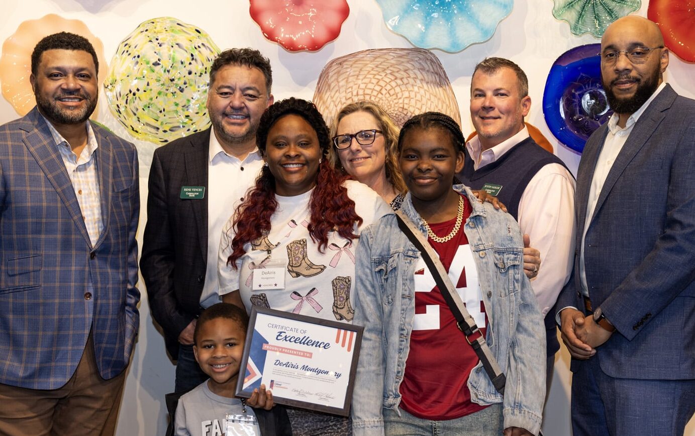 DeAiris Montgomery, one of our Client Celebration honorees, posing for a picture with her two young children and members of the Carollton Bank team.