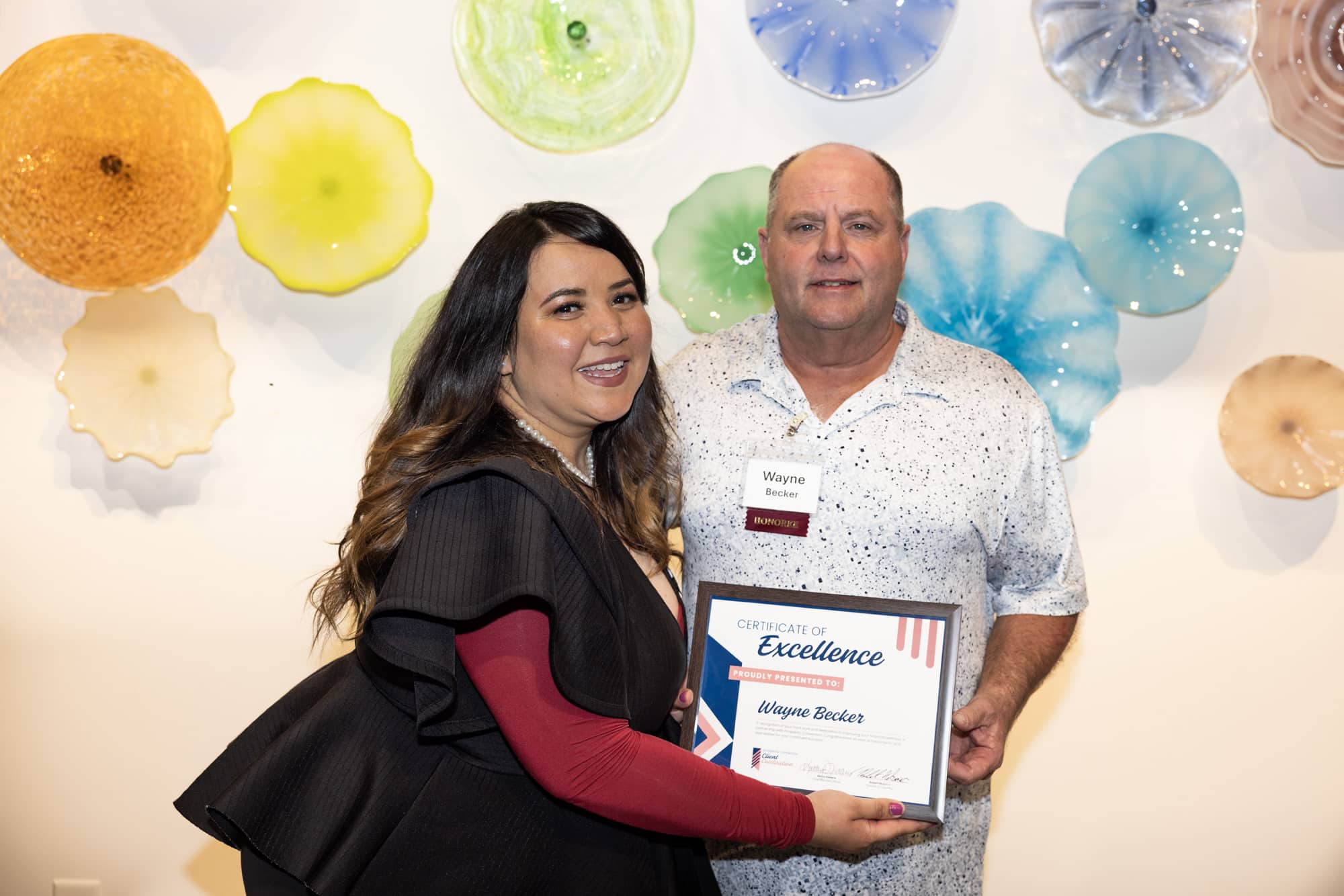Wayne Becker poses with his financial coach Veronica Guerrera as they celebrate his success.