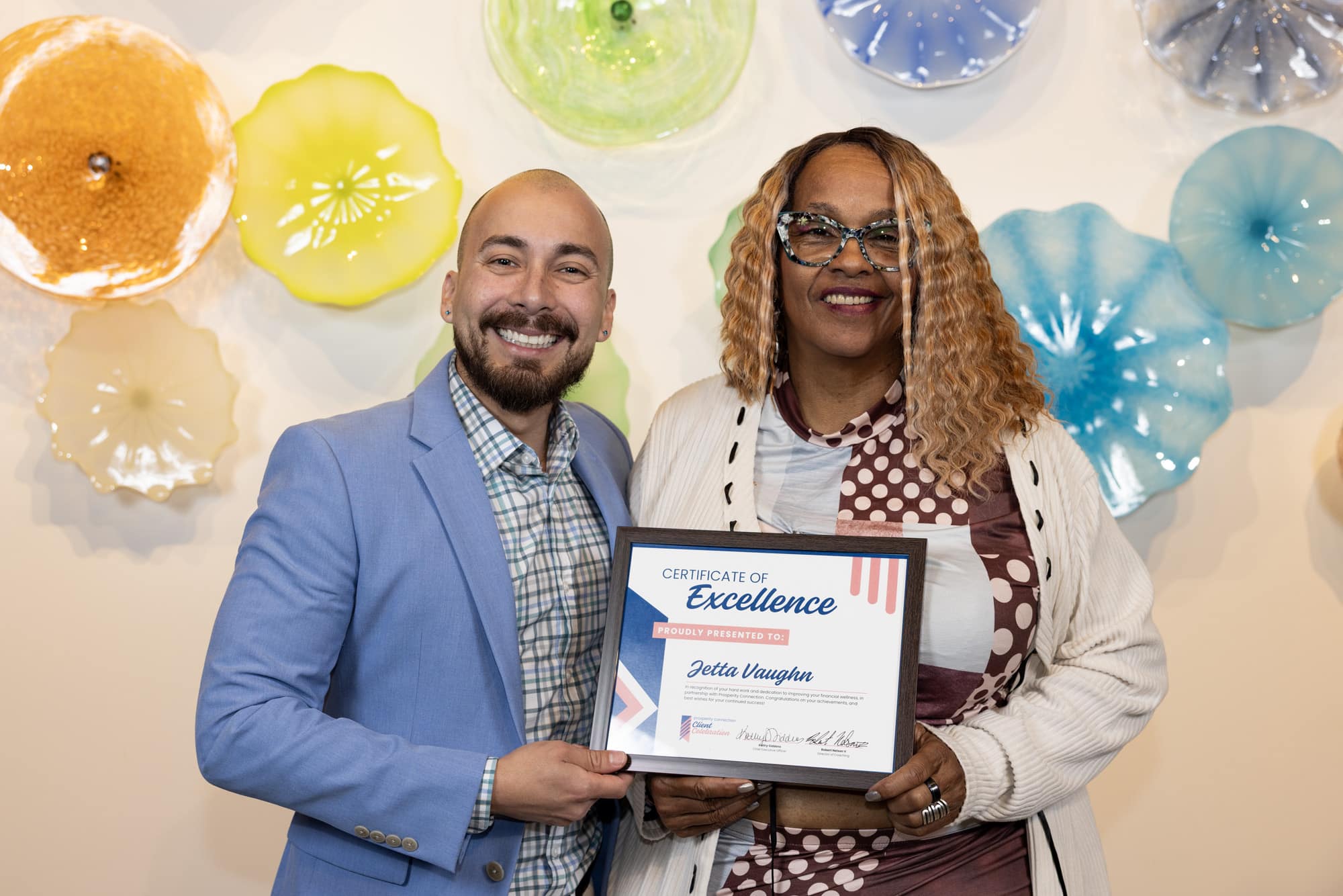 Jetta Vaughn stands with her financial coach Pablo Giraldo as they celebrate her success.